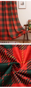 Detailed close-up of thick woven red and green plaid Christmas blackout window curtain fabric