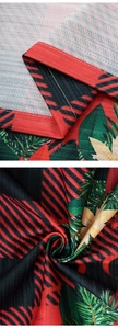Detail of Christmas plaid curtains showing woven texture, pine prints, and red edge stitching