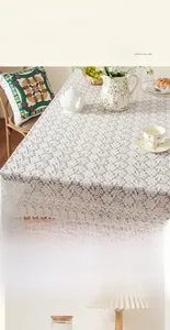 Detail of vintage French lace tablecloth featuring intricate hollow-out floral patterns