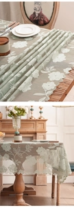 Detailed close-up of light green floral embroidered lace tablecloth with scalloped edges