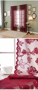 Détail de rideau en dentelle bordeaux avec broderie de rose et bord festonné