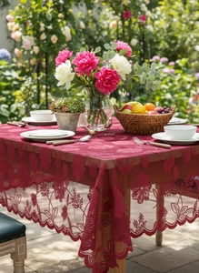 Detail showing deep red lace tablecloth with exquisite floral embroidery and wavy edges