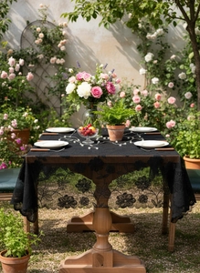 Detailed close-up of black floral lace tablecloth with scalloped edges on outdoor table