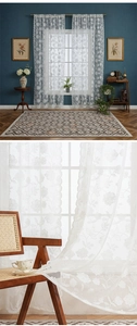Close-up of elegant white floral embroidery on sheer lace curtain fabric with a soft drape