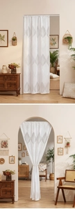 Detail of white lace door curtain with grey leaf pattern in a cozy home interior setting