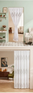 Detail of white lace door curtain with grey leaf pattern in a modern cozy room setup
