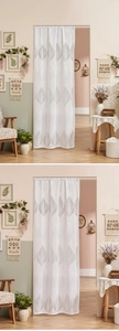 Detail of white lace door curtain with grey leaf pattern in a cozy bedroom setting