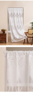 Detailed close-up of white lace door curtain featuring delicate gray leaf patterns