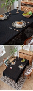 Close-up of black rectangular tablecloth with geometric lace patterns and jacquard texture