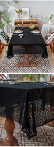 Close-up of black lace tablecloth featuring geometric hollow-out patterns and wavy edges