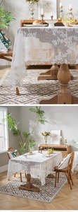Detailed close-up of intricate rose lace patterns on a white rectangular tablecloth