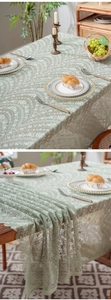 Close-up of light green lace tablecloth featuring intricate floral and paisley patterns