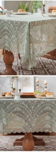 Detail view of light green lace tablecloth showing vintage floral patterns and wavy edges
