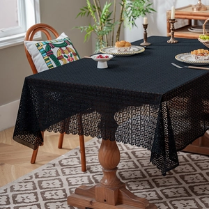 Modern black lace tablecloth featuring geometric patterns and elegant wavy edges for dining tables