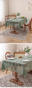 Close-up of dark green lace tablecloth featuring intricate floral patterns and scalloped edges
