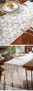 Detailed close-up of white lace table runner featuring butterfly embroidery and fringe edge