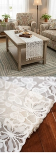 Detail of white lace table runner with floral butterfly patterns and tassel trim