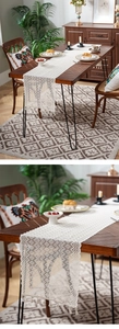 Macro detail of white crochet table runner with hollow geometric patterns and fringe