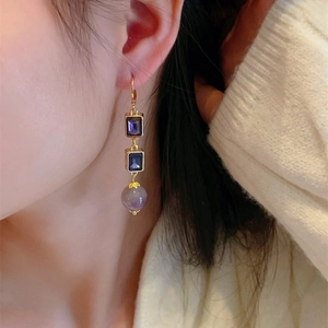Detail of vintage purple crystal drop earrings with gold frame on a model