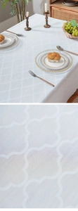 Dettaglio della tovaglia jacquard bianca con eleganti motivi a trifoglio e trama del tessuto