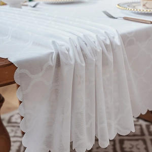 Elegante tovaglia bianca con trama jacquard geometrica e bordo smerlato a onde