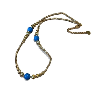 Elegant gold beaded necklace with three blue turquoise stones on white background