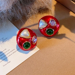 Detail of vintage red enamel earrings with colorful gems and gold metal base