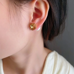 Elegant amber square crystal stud earrings with gold plating on a model