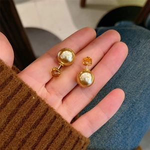 Detail showing amber faceted gemstone and golden pearl on versatile double-sided earrings