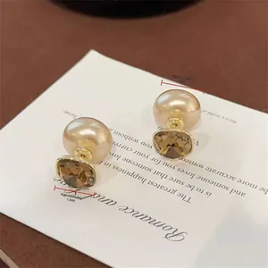 Detailed size view of tea-brown crystal and pearl earrings measuring 1.3cm and 1.2cm