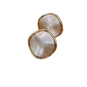 Minimalist brushed metal earrings with wavy gold frame and light textured inlay