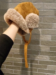 Détail du chapeau trappeur en daim marron avec doublure en laine d'agneau et lanières