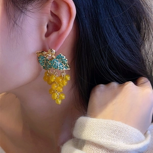 Detailed close-up of grape-shaped earrings featuring green rhinestones and yellow beads