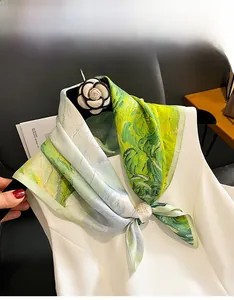 Detailansicht eines Seidentuchs im Ölgemälde-Stil mit Kamelien-Brosche auf Weiß