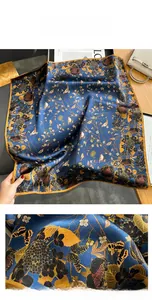 Detailed view of dark blue silk scarf showing intricate floral and bird print patterns