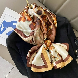 Élégant foulard en soie à imprimé abstrait ambre présenté sur un pull noir sophistiqué