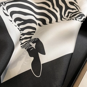 Close-up of zebra print silk scarf showing satin texture and geometric monochrome pattern