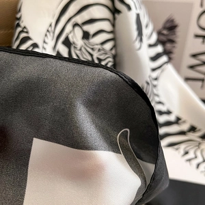 Detailed view of black and white zebra pattern silk scarf with fine rolled edge stitching