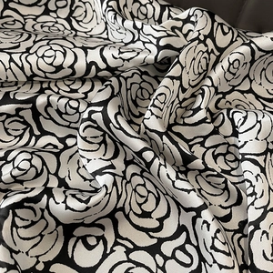 Macro view of black and white rose pattern on high-quality silk satin fabric texture