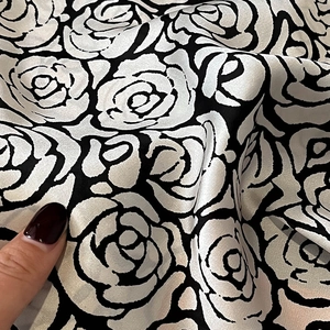Detail of silk-satin scarf fabric with high-contrast black and white rose floral pattern