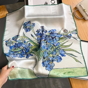 Fashionable silk square scarf with Van Gogh Iris print on a wooden table with accessories