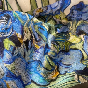 Close-up of silk scarf showing artistic van Gogh iris print and satin texture