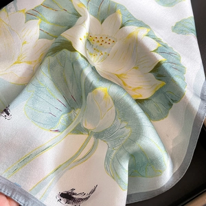 Detail of silk scarf showing lotus and koi fish print with elegant satin luster finish