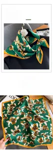 Détail d'un carré de soie avec imprimés roses orange vintage sur fond vert foncé