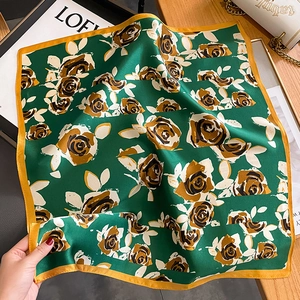 Foulard élégant en soie vert émeraude avec imprimés roses et bordures dorées sur bois