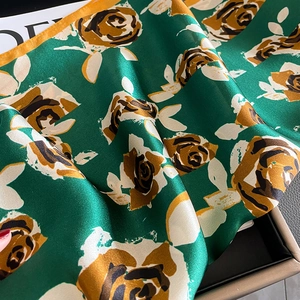Carré en soie vert foncé avec imprimé roses vintage et fini satiné sur présentoir chic
