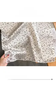 Détail d'un foulard en soie à pois avec bordures cousues fines pour une sensation douce