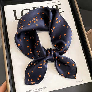 Foulard en soie bleu marine à pois orange vif noué avec élégance pour femme chic