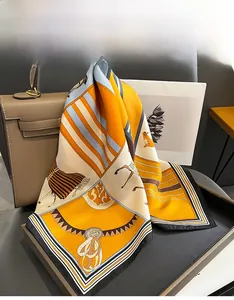 Close-up of silk square scarf featuring equestrian patterns draped on a luxury leather bag