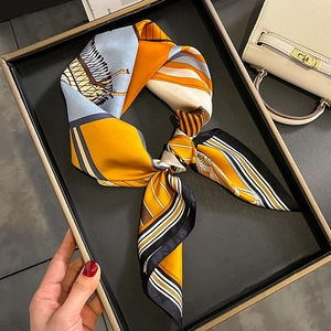 Silk square scarf with equestrian print and colorful stripes in a minimalist luxury setting